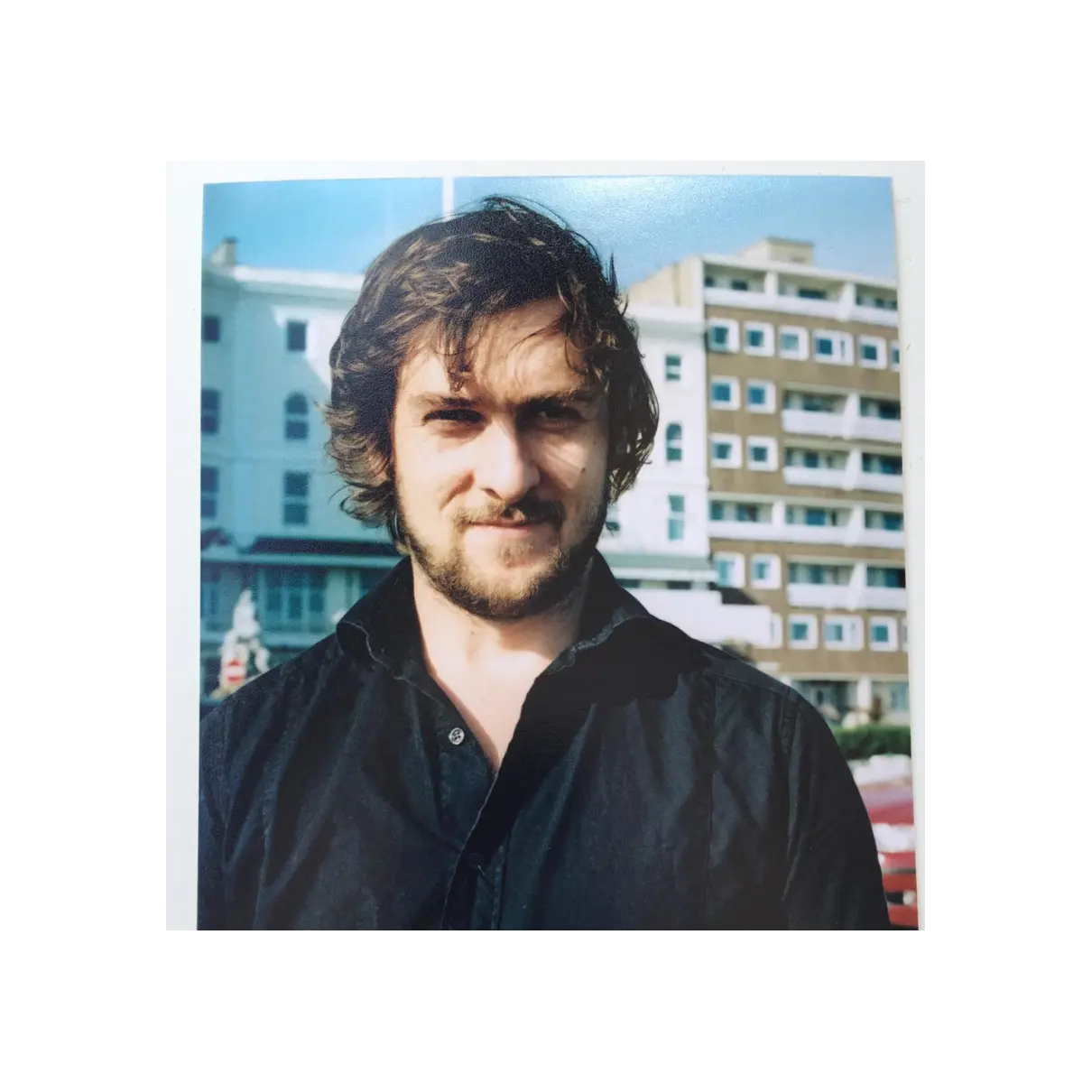 Photo of Alex aged 19 standing in the sun on Brighton Seafront